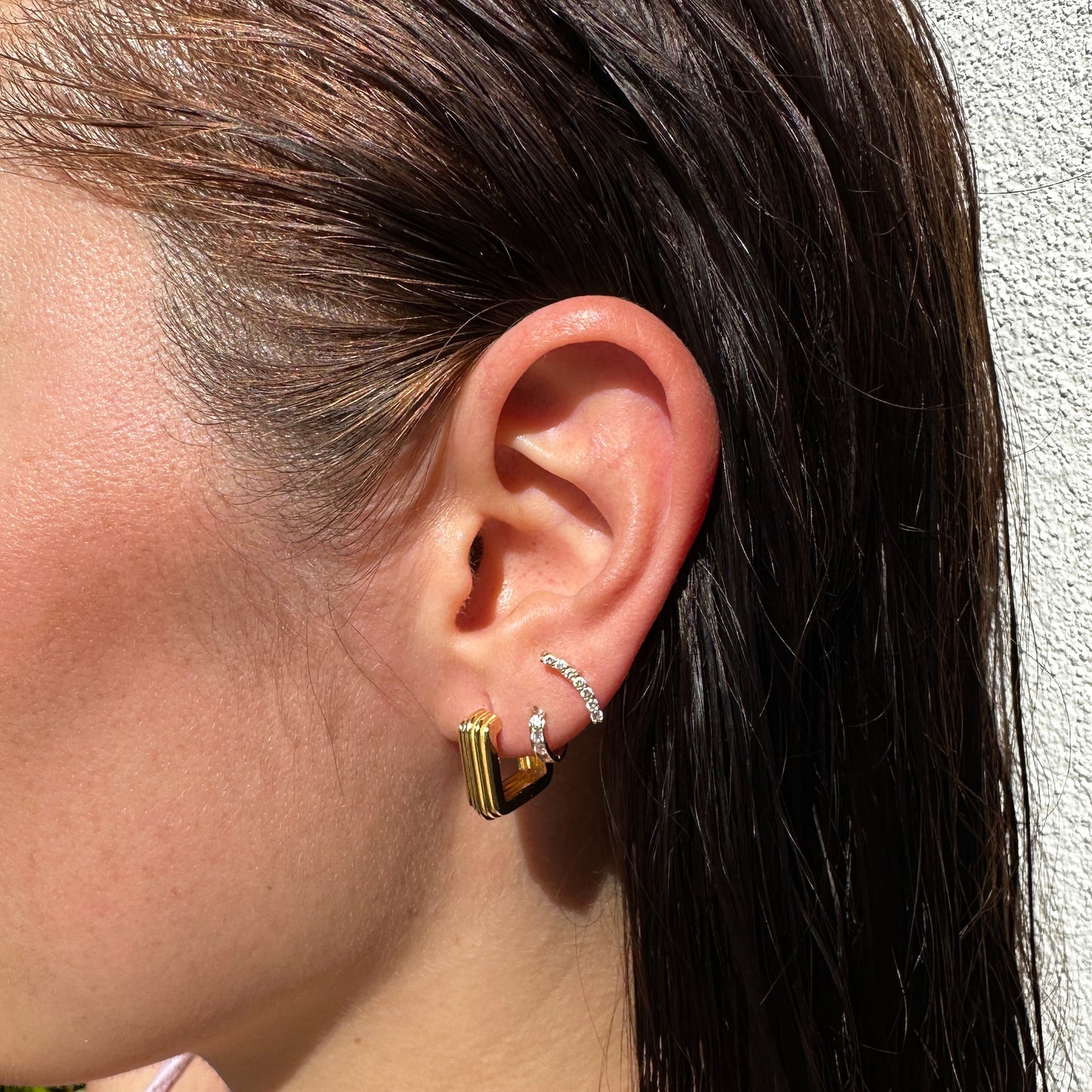A close up of female model's ear wearing the 18K Gold Filled Grooved C-Hoop Earrings