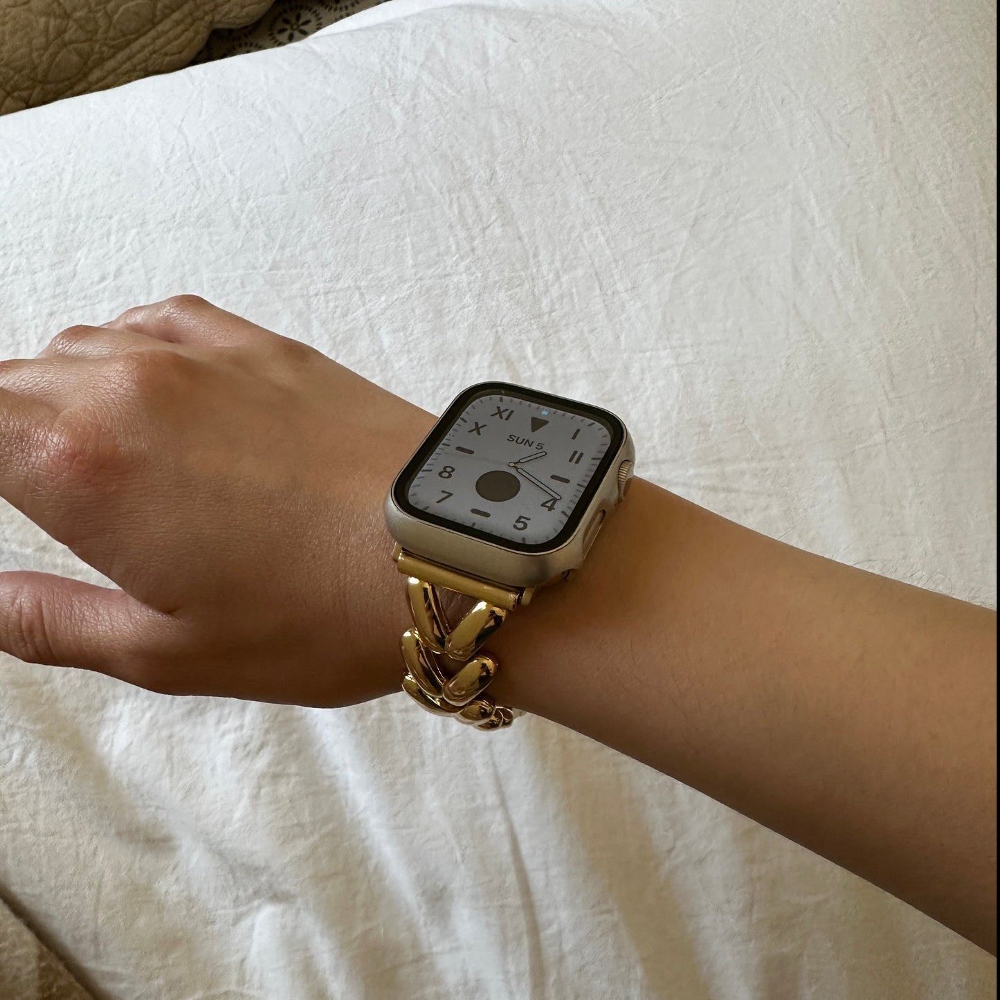 The Gold-Tone Alloy Link Chain Watch Band Compatible with Apple Watch worn on a female models wrist shown from above angle