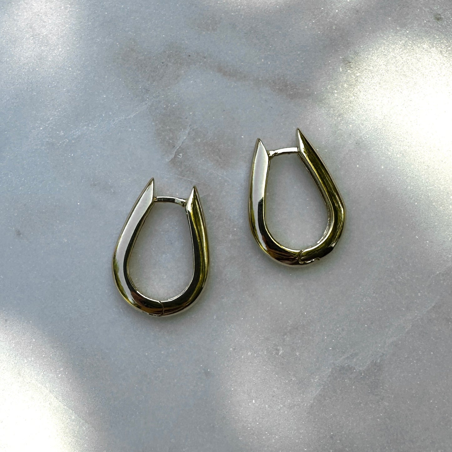 A close up product image of the 18K Gold Filled Chic U-Shaped Hoop Earrings from an above angle