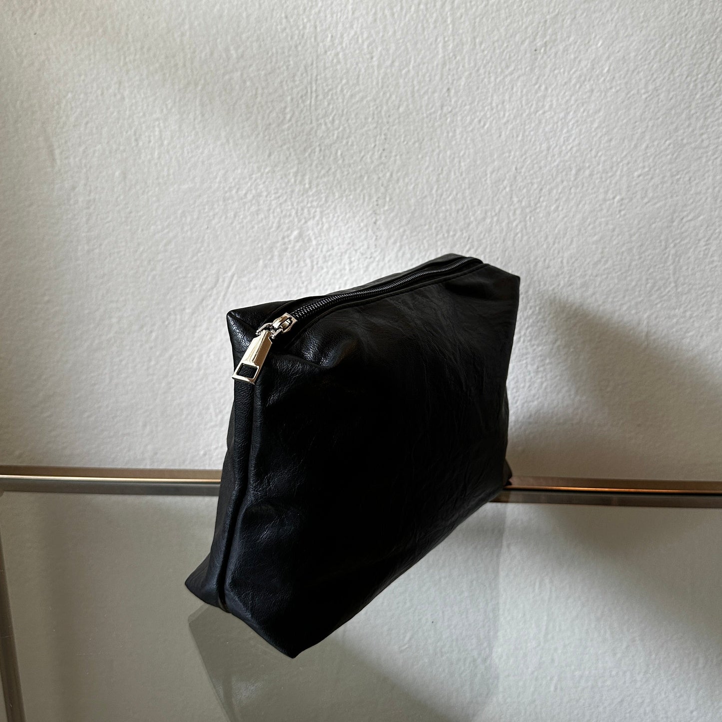 The Black Vegan Leather Pouch shown at a side angle