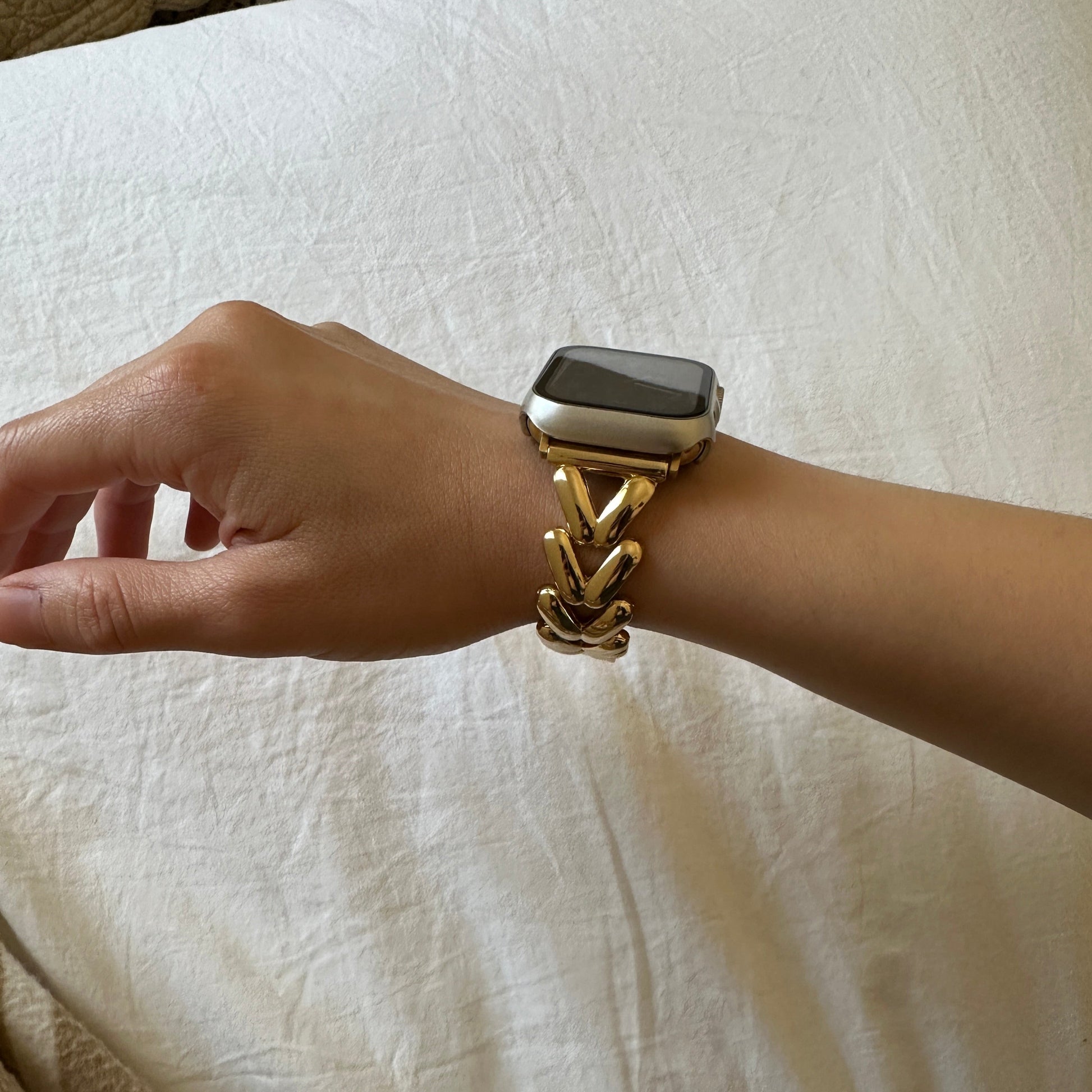 The Gold-Tone Alloy Link Chain Watch Band Compatible with Apple Watch worn on a female models wrist shown from a side angle