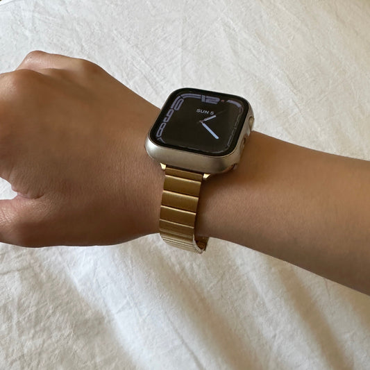 Close up image of the Gold-Tone Stainless Steel Sleek Watch Band Compatible with Apple Watch worn on female models wrist